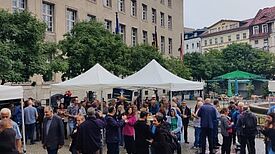 Auf dem Vorplatz des Rathaus Neuköllns trotzen die Feiernden dem Nieselregen. (Bild: Birgit Leiß)