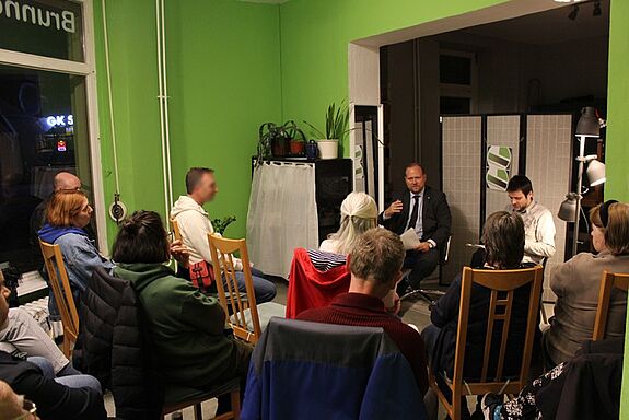 Diskussionsrunde mit Bezirksstadtrat Benjamin Fritz im Kiezeck Brunnenstraße; Anwohnende beteiligen sich am Gespräch zur Schulsanierung des Quartiers.
