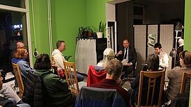 Diskussionsrunde mit Bezirksstadtrat Benjamin Fritz im Kiezeck Brunnenstraße; Anwohnende beteiligen sich am Gespräch zur Schulsanierung des Quartiers.