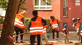 Freiwillige in Westen mit der Aufschrift Kehrenbürger bei Reinigungsarbeiten.