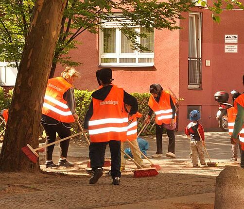 Freiwillige in Westen mit der Aufschrift Kehrenbürger bei Reinigungsarbeiten.