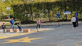 Mehrere Jugendliche spielen gemeinsam draußen Federball.