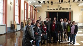 In der Aula der Kepler Oberschule: Senator Geisel (8.v.r.), Bezirksstadtrat Blesing (7.v.r.), Abgeordneter Langenbrink (MdA) (10.v.r.), Geschäftsführer Malter (5.v.r.) der Stadt und Land Wohnbauten GmbH, Schulleitung, Quartiersräte und Stadtteilmütter Bil