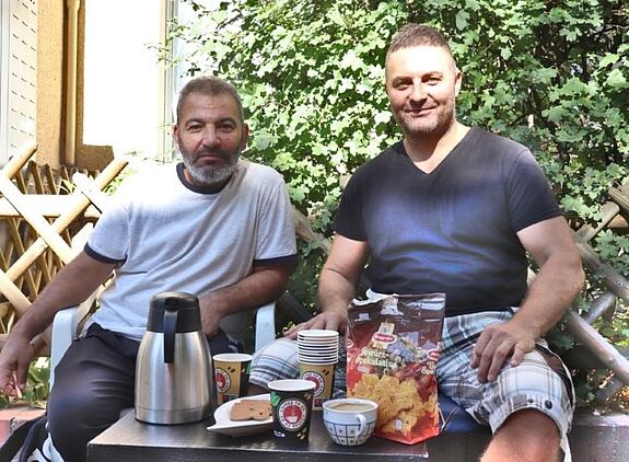 Eine Familie lädt Passantinnen und Passanten zu einer kleinen Kaffeepause auf dem Bürgersteig ein. (Bild: Andrei Schnell, QM-Team)