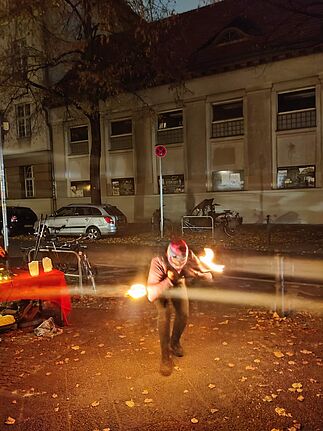 Ein Künstler hantiert bei der Feuershow mit dem Motto „Ein Licht für den Frieden“ mit einem brennenden Stab. 