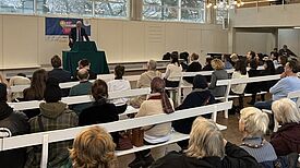 Stephan Machulik spricht vor Zuhörerinnen und Zuhörern im Saal der Brüdergemeinde beim Neujahrsempfang des Verbands für dezentrale Stadtteilarbeit Rixdorf.
