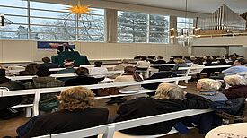 Stephan Machulik spricht vor Zuhörerinnen und Zuhörern im Saal der Brüdergemeinde beim Neujahrsempfang des Verbands für dezentrale Stadtteilarbeit Rixdorf.