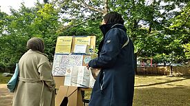 Zwei Personen stehen vor einer Stellwand, die das Projektteam mitgebracht hat.