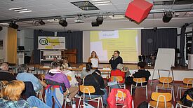 Menschen sitzen in einem Raum, während beim Nahariyaforum in der Nahariya-Schule eine Präsentation gehalten wird.
