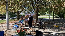 Zwei Personen stehen bei der Auftaktveranstaltung am 1. August 2024vor einer Pinnwand im Freien und besprechen Vorschläge zur Neugestaltung des Marktplatzes.