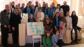 Viele Menschen stellen sich zusammen für ein Foto. 