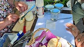 Eine Tafel ist reichhaltig mit Brot, Butter, frischen Kräutern, Gläsern und Milch gedeckt. 
