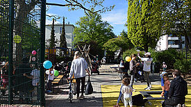 Familien und Kinder spielen bei der Eröffnung auf dem Spielplatz Bendastraße. 