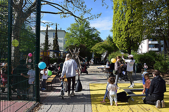 Familien und Kinder spielen bei der Eröffnung auf dem Spielplatz Bendastraße. 
