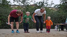 Zwei Trainer und zwei Kinder machen Bewegungsübungen.