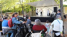 Zuschauer mit und ohne Behinderung beim Bühnenprogramm des Kiezfests.   Foto: QM Rollbergsiedlung 