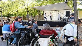 Zuschauer mit und ohne Behinderung beim Bühnenprogramm des Kiezfests.   Foto: QM Rollbergsiedlung 
