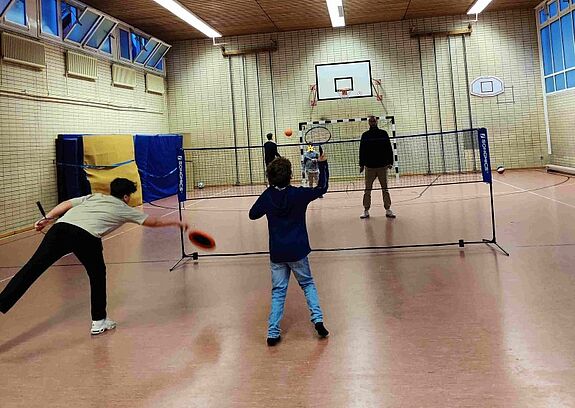 Kinder spielen Badminton in der Turnhalle der Hermann-Boddin-Schule.
