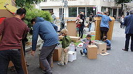 Kinder und Erwachsene bemalen Kisten auf der Straße 