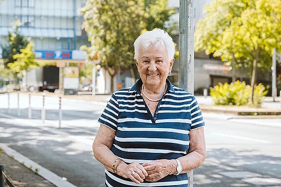 Margareta Grothehusmann lächelt vor einer Baumallee in der High-Deck-Siedlung.