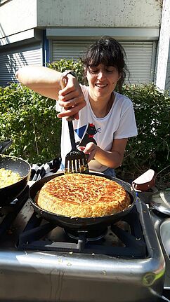 Eine Anwohnerin bereitet an der mobilen Küche des Gemeinschaftsgartens Tortilla zu. 
