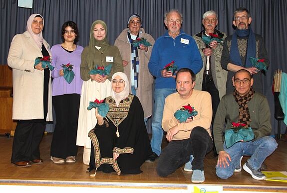 Eine Menschengruppe mit Blumen posiert für ein Foto.