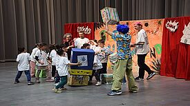 Die Kinder spielen auf der Bühne gemeinsam mit Lorenzo Pennacchietti das Theaterstück „Der Groll-Junge“.