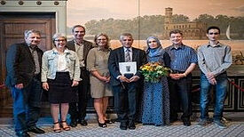 Moussa Isse im Kreise seiner Familie, mit Stadträtin Sibyll Klotz (4.v.l.), dem Laudator Ralf Koch (2.v.r.), Corinna Lippert, Remzi Uyguner und Peter Pulm Bild: Bezirksamt Tempelhof-Schöneberg, Aurelio Schrey, Alexander Meyer (QM)
