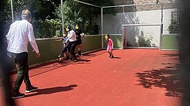 Kinder und Erwachsene spielen auf dem neuen Fußballplatz der Löwenzahn-Grundschule im QM-Gebiet Rixdorf.