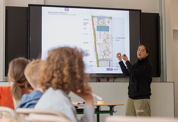 Eine Architektin präsentiert Schulkindern am Bildschirm einen Entwurf zur Neugestaltung des Schulhofs der Evangelischen Schule Neukölln.