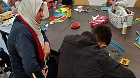 Ein Kind und eine Frau basteln gemeinsam beim Angebot in der Geflüchtetenunterkunft, das durch den Aktionsfonds ermöglicht wurde. 