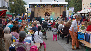 Blick auf lange Tafel und Bühne beim Sommerfest im Quartier Mehringplatz.