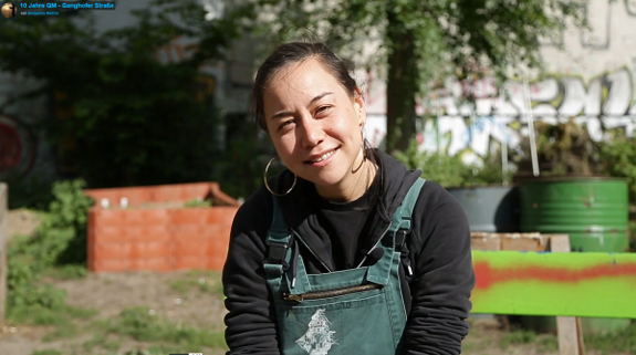 Larissa vom Gemeinschaftsgarten Karma Kultur. Standbild aus dem Film „10 Jahre QM Ganghofer Straße“ von Benjamin Riehm