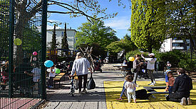 Familien und Kinder spielen bei der Eröffnung auf dem Spielplatz Bendastraße. 
