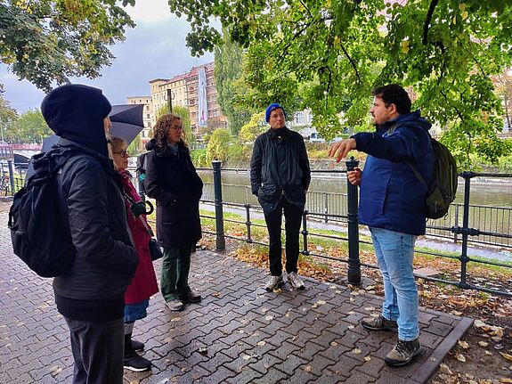 Tourguide Abuhanna Muosa redet mit den Teilnehmenden des Spaziergangs.