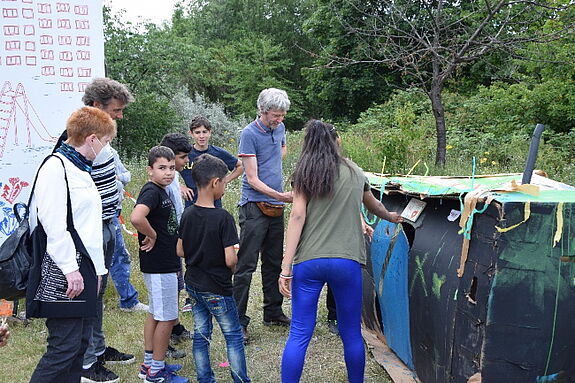 Die Kinder erklären Petra Pau (links) die Ideen hinter dem „Ausländerhaus mit Herz“. Bild: QM Kastanienallee.