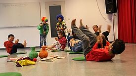 Kindergartenkinder turnen auf dem Boden.