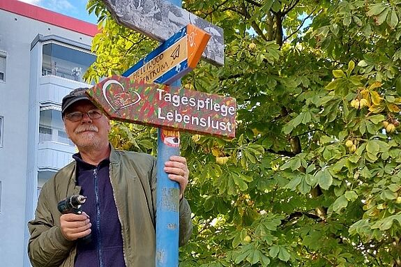 Der engagierte Anwohner und Künstler Jörg Weber half dabei, die neuen bunten Holzschilder zu befestigen. (Bild: SmArt GbR)