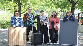 Drei Mitarbeitende des Internetunternehmens stehen gemeinsam mit den Quartiersmanagerinnen Dalia Lüttgert und Teresa Rodenfels im QM-Gebiet Titiseestraße.