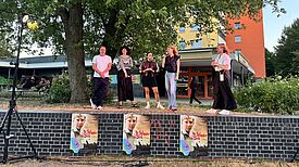 Fünf Personen stehen auf einer Mauer, die als Bühne genutzt wird und mit Plakaten des Films „Das Wunder von Bern“ beklebt ist.