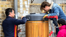 Mehrere Teilnehmende bauen gemeinsam die neue Regentonne auf.