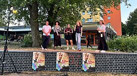 Fünf Personen stehen auf einer Mauer, die als Bühne genutzt wird und mit Plakaten des Films „Das Wunder von Bern“ beklebt ist.