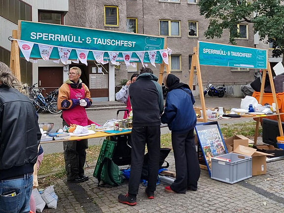 Menschen an einem Stand vom Projekt „Prima Klima“ auf Sperrmüll- und Tauschfest im Gespräch mit dem Projektteam. 