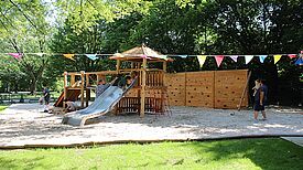 Auf dem frisch angepflanzten Rasen hinter dem Kieztreff stehen jetzt Hochbeete, es gibt einen neuen Spielplatz für kleinere Kinder und ein Gartenhaus für Gerätschaften und Spielsachen. (Bild: QM Thermometersiedlung)
