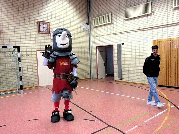 Maskottchen Ritter Keule und ein Trainer von Union Berlin in der Turnhalle der Hermann-Boddin-Schule.
