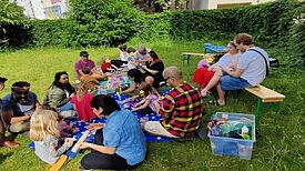 Kinder und Eltern gestalteten im Rahmen des Projekts „Familien in Bewegung: Unsere Bibliothek“ bunte Alebrijes auf der Wiese im Flughafenkiez. (Bild: QM Flughafenstraße)