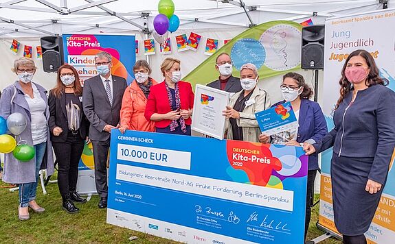 Nach den Grußworten übergaben Dr. Franziska Giffey (5. von links) und Bildungssenatorin Sandra Scheres (ganz rechts) symbolisch einen großen Scheck über 10.000 Euro an die „AG Frühe Förderung“. (Bild: Ralf Salecker)