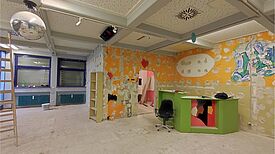 Der MaDonna Mädchentreff befindet sich im Umbau: im Raum stehen Leiter, grüne Theke und Baumaterial, die Wände sind teils ausgebessert und bunt gestrichen.