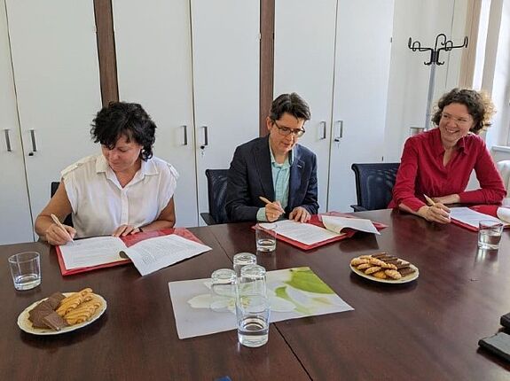 Irina Herz von der GESOBAU AG, Dr. Sandra Obermeyer, Abteilungsleiterin Quartiersentwicklung der Senatsverwaltung für Stadtentwicklung, Bauen und Wohnen und Korinna Stephan, Reinickendorfer Bezirksstadträtin für Stadtentwicklung (von links nach rechts) unterzeichnen die Kooperationsvereinbarung. (Foto: Bezirksamt Reinickendorf)