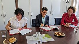 Irina Herz von der GESOBAU AG, Dr. Sandra Obermeyer, Abteilungsleiterin Quartiersentwicklung der Senatsverwaltung für Stadtentwicklung, Bauen und Wohnen und Korinna Stephan, Reinickendorfer Bezirksstadträtin für Stadtentwicklung (von links nach rechts) unterzeichnen die Kooperationsvereinbarung. (Foto: Bezirksamt Reinickendorf)